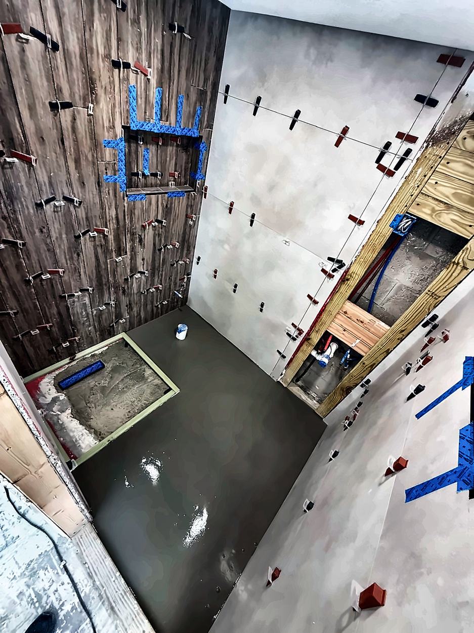 Self-levelling compound poured on the floor with the linear drain pan bedded to its fall