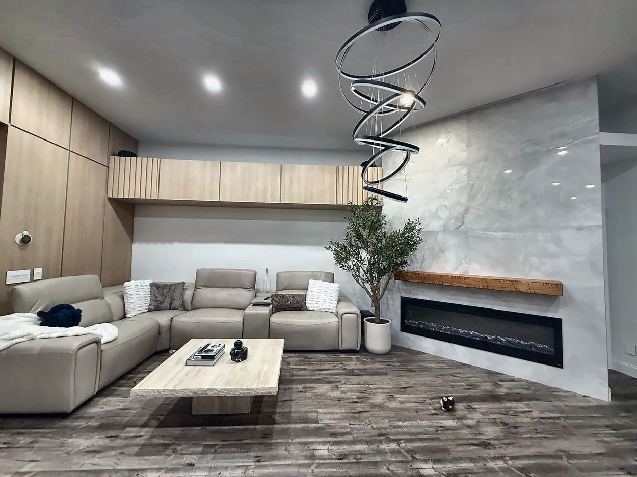 The same wall after renovation: a full-height marble-look plaster slab with a linear fireplace, the original timber mantel reinstalled, and a run of light oak cabinetry with a fluted panel where the soffit used to be