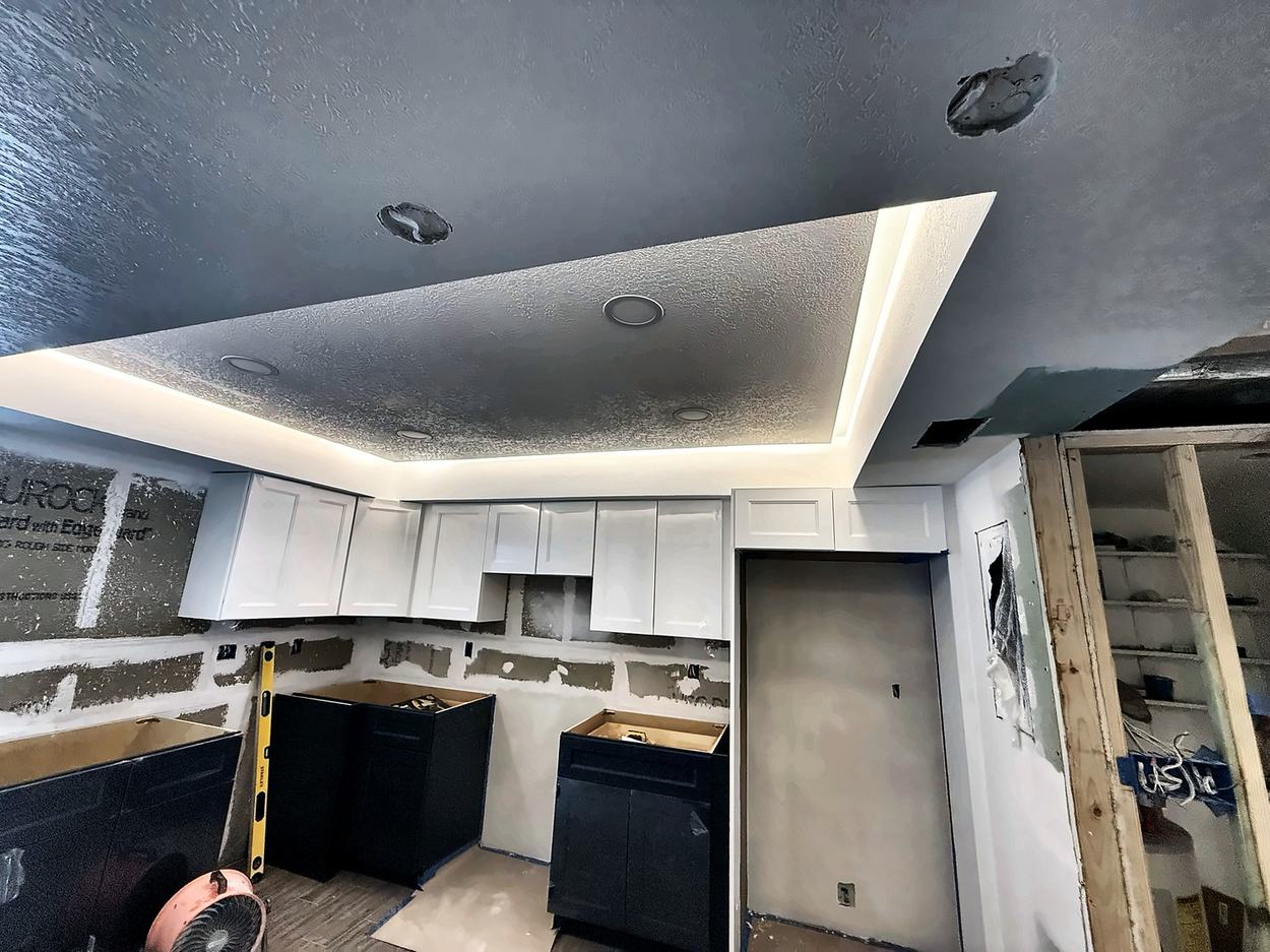 Dropped soffit with concealed cove LED already lit, cabinets hung, walls still in cement board