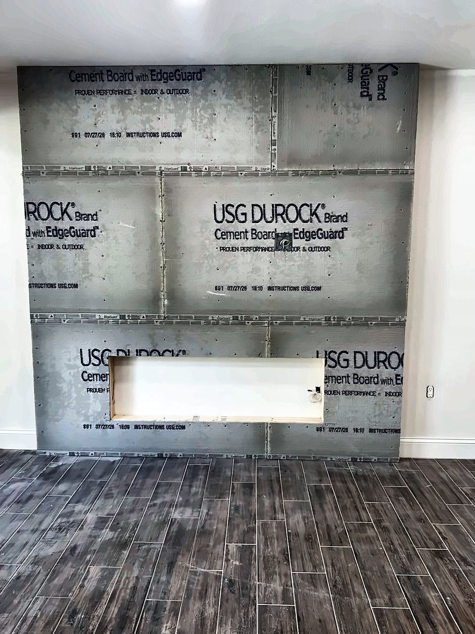 The same wall sheathed in cement board with the fireplace niche left open