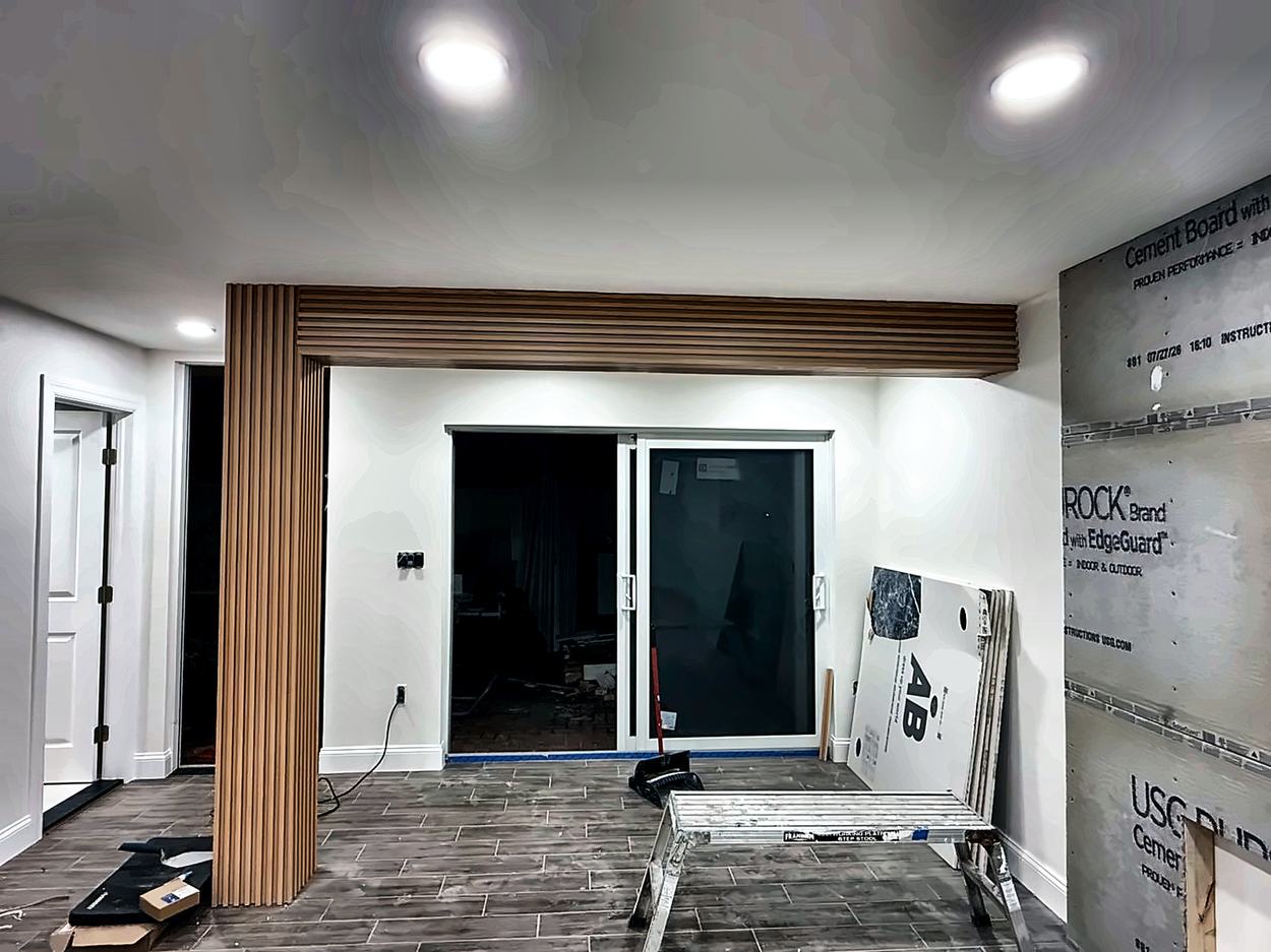 Fluted column and matching slatted beam wrapping the opening, cement board still exposed