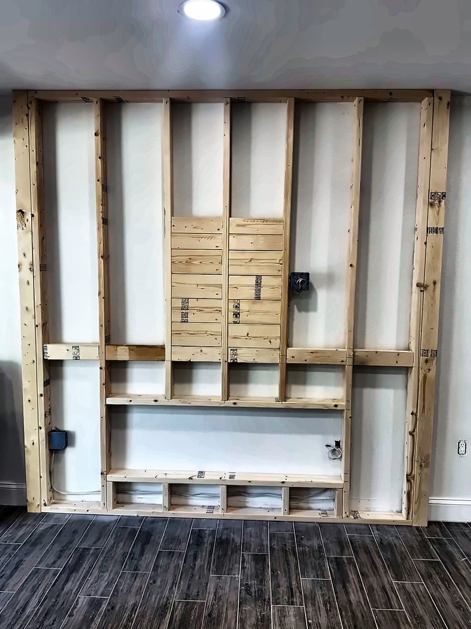 New stud wall framed out in front of the existing wall with a boxed fireplace opening